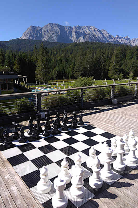 Die Ruhe rund um das idyllisch gelegene Hotel Kranzbach lädt zu einer Partie Schach vor der Bergkulisse des Karwendelgebirges ein.